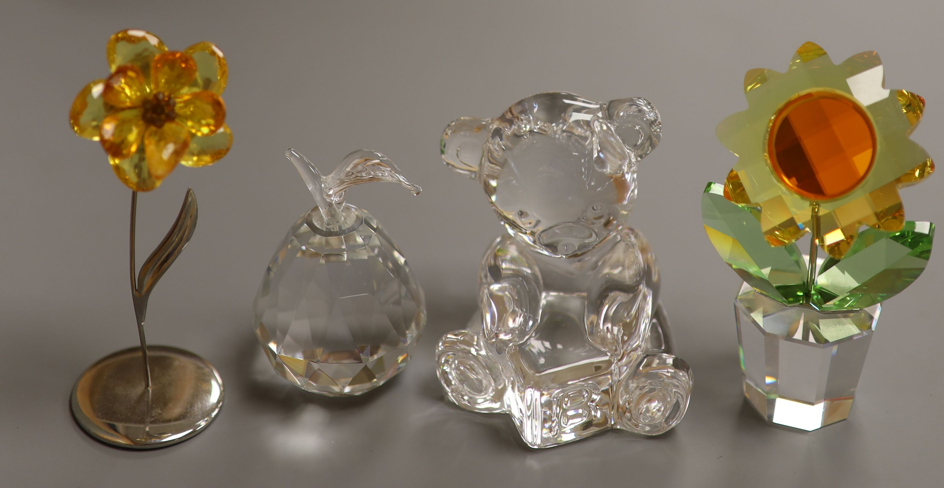 A Swarovski 'Sunflower', with topaz centre and yellow petals in clear glass pot (boxed), a smaller yellow flower and a Waterford crystal teddy bear